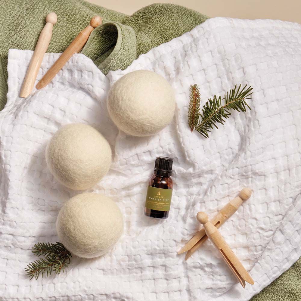 Frasier Fir Wool Dryer Balls & Laundry Fragrance Oil flat lay on towels with clothes pins image number 3